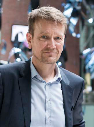 Jörg Wallner lehnt an einem Geländer - Director Innovation & Change bei 2b AHEAD ThinkTank